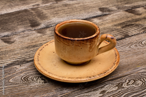 Small cup of coffee on wooden background