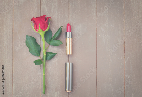 Still life with fresh rose flower and red lipstick, retro toned photo