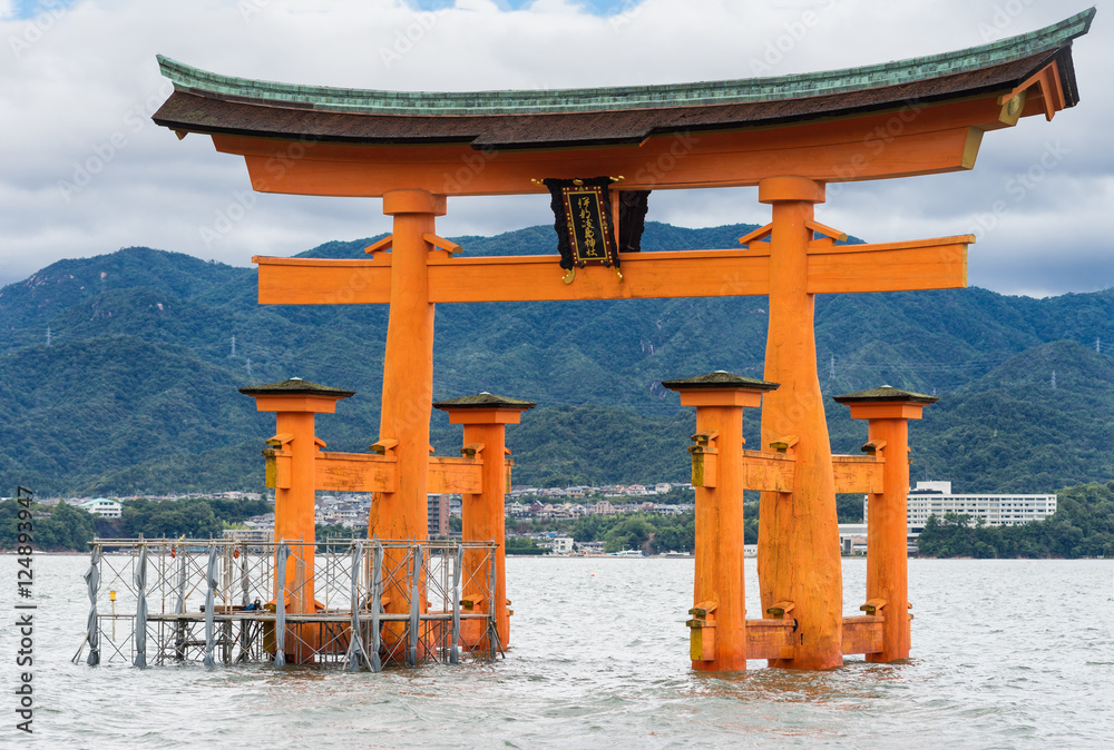 Hiroshima, Japan - September 20, 2016: Iconic historic vermilion Torii in front of Itsukushima Shinto Shrine stands in the water of the Inland Sea off Miyajima Island. Hiroshima, Japan - September 20, 2016: Iconic historic vermilion Torii in front of Itsukushima Shinto Shrine stands in the water of the Inland Sea off Miyajima Island.