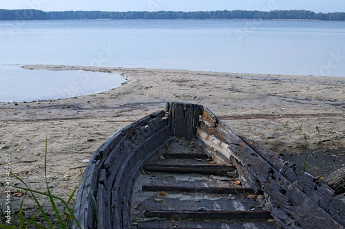 Old abandoned wooden boat on the lake. close-up of the nose of the boat photo