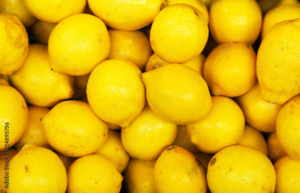 Lot of bright yellow lemons in supermarket.