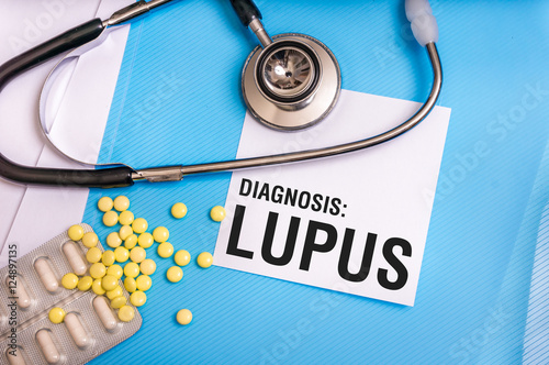 Lupus word written on medical blue folder with patient files photo