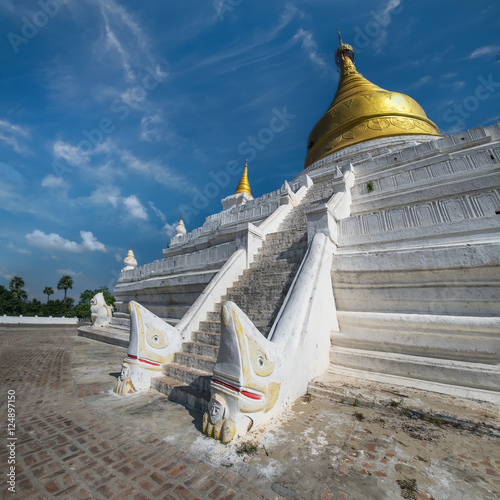 White Pagoda at Inwa ancient city with lions guardian statues. Amazing architecture of old Buddhist Temples. Myanmar (Burma) travel landscapes and destinations photo