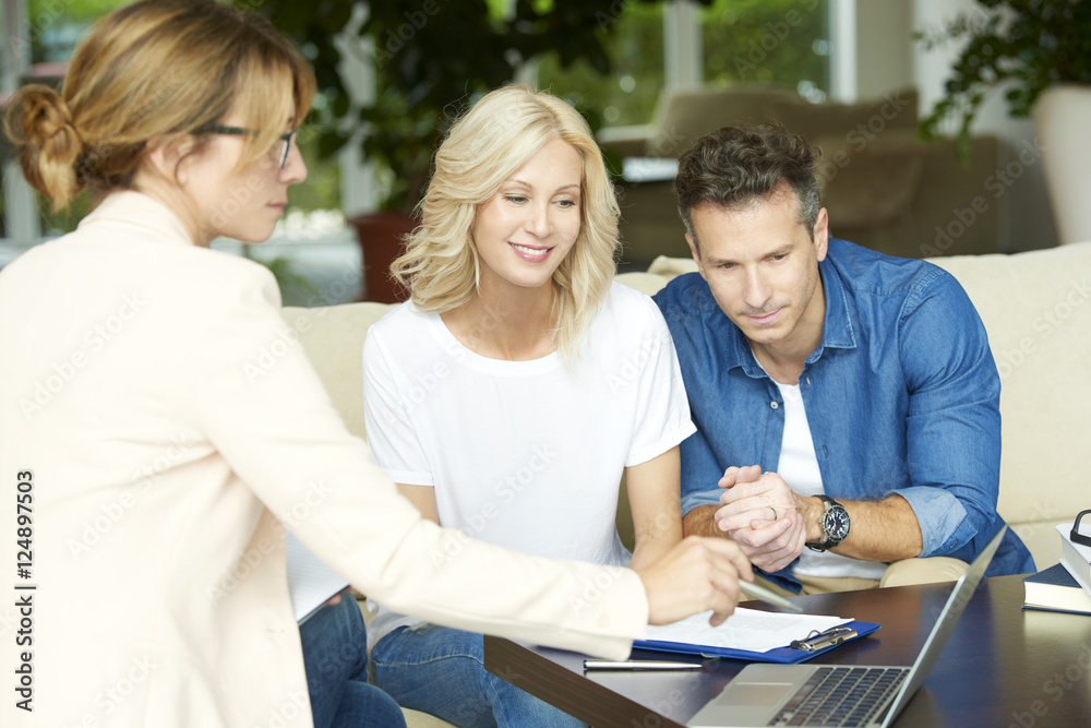 Shot of an investment advisor businesswoman consulting with middle aged couple in their home. Shot of an investment advisor businesswoman consulting with middle aged couple in their home.