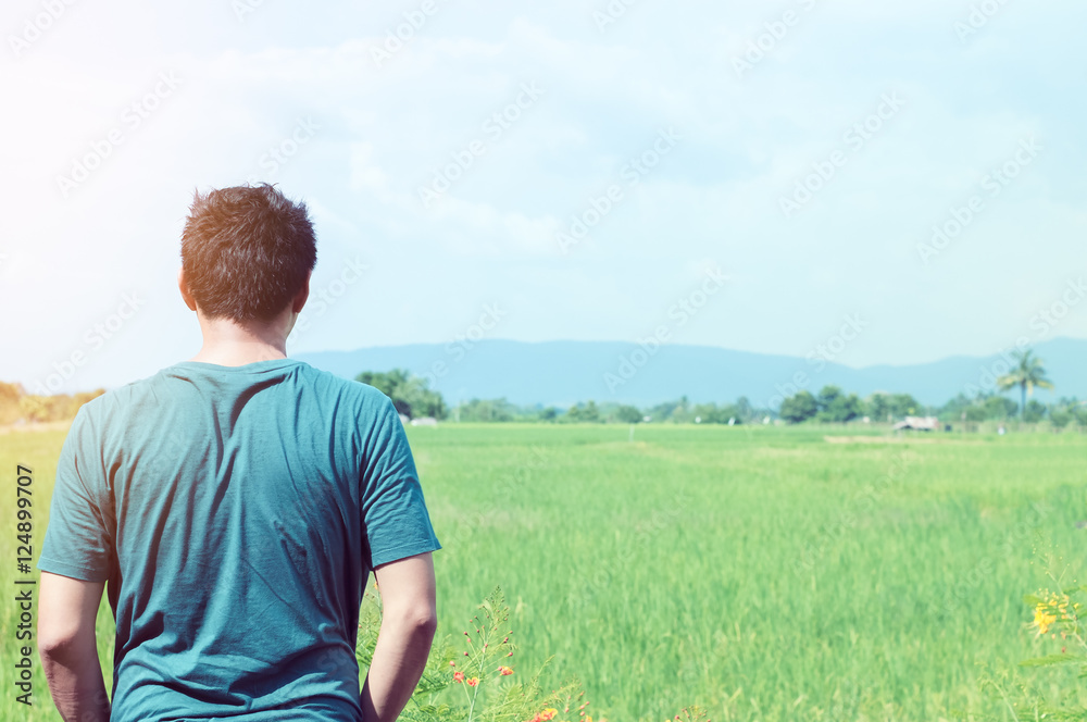 Young man is looking at the rice field