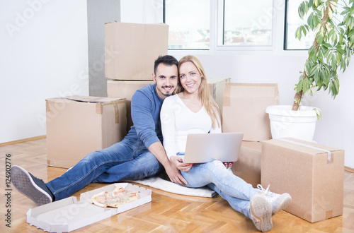 Couple celebrating moving Into new home with pizza   © Addoro