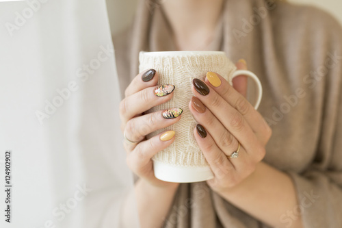 Bild auf Leinwand hands of autumn nails holding a cup of hot tea