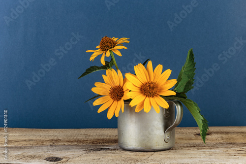 Tableau sur toile Wild flowers in an aluminum mug on a wooden table