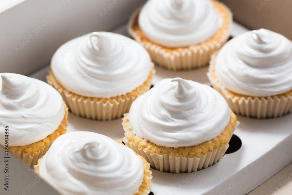 Cupcake packaging, delivery box, vanilla cupcakes with white cream, selective focus, close up Cupcake packaging, delivery box, vanilla cupcakes with white cream, selective focus, close up