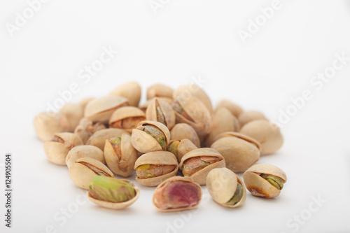 Heap of dry salted pistachio fruit on white background