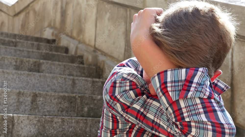 Depressed teenager boy sitting on stairs. Depression concept Depressed teenager boy sitting on stairs. Depression concept