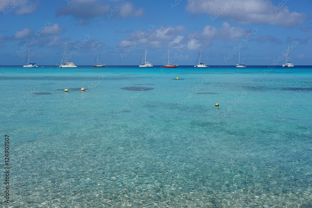 Seascape of a tropical lagoon with turquoise water and boats anchored, south Pacific ocean, atoll of Rangiroa, Tuamotu archipelago, French Polynesia

