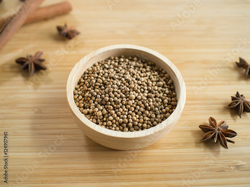 Coriander seeds in wooden bowl  and on twooden board.