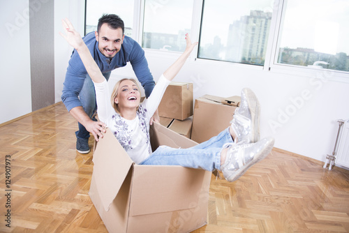 Couple with cardboard boxes having fun 
