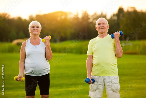 Old couple with dumbbells. People doing physical exercise. Always believe in yourself. Never too late to start.