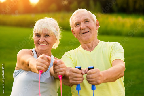 Smiling couple of seniors outdoor. People holding skipping ropes. Small victories in sport. Improve your results.