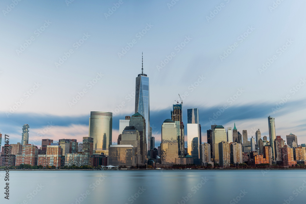 Obraz premium Downtown New York skyline stands tall as sun sets in the east. 