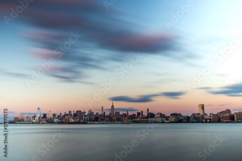 Long exposure of a clouds over a city and river looking like frozen water.