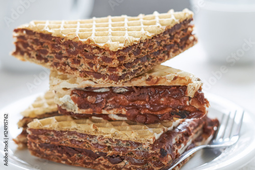Stack of wafer sheets filled with caramelized sugar and hazelnut cream served on white plate