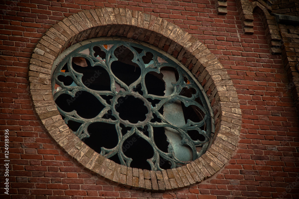 Round castle window with broken stained-glass windows