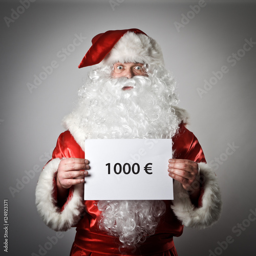 Santa Claus is holding a white paper in his hands. One thousand
