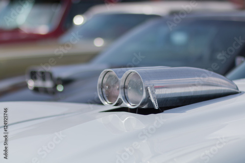 Close-up of an old car. Part of the exterior. An American classic. Chrome lining. Glass with reflection.