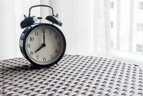Still life with vintage alarm clock on weave table ( alarm clock