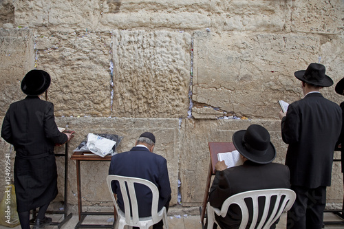 men praying at western wall