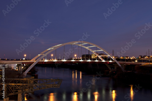 Beautifully lit arched bridge with colorful reflections
