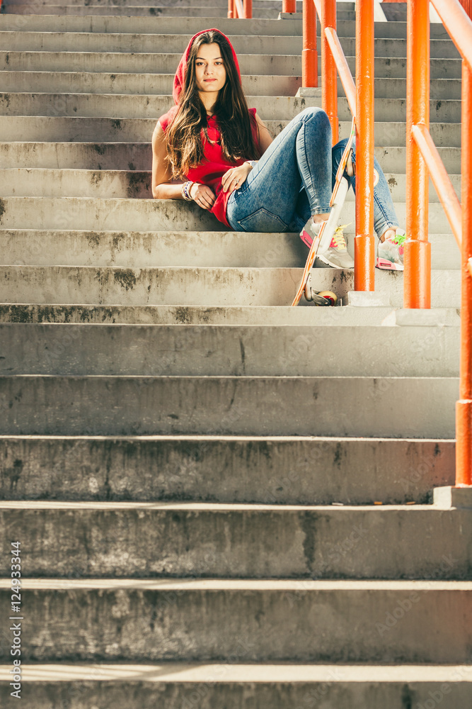 Skate girl on stairs with skateboard.