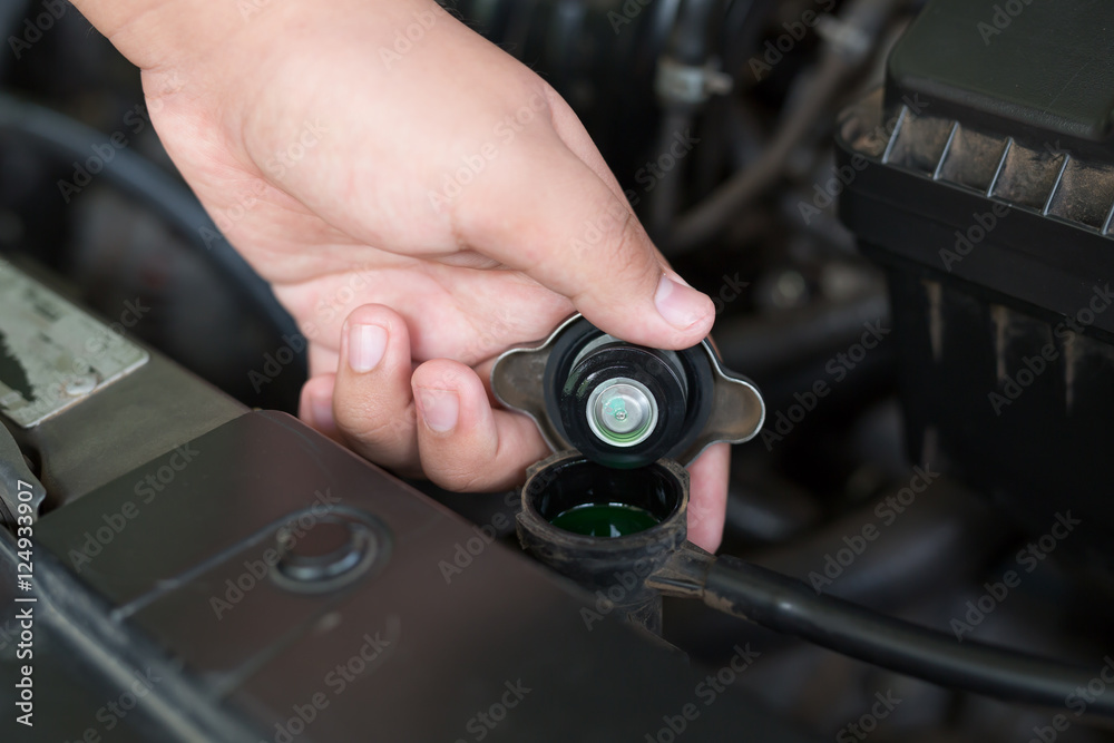 Closeup hand open valve metal cover on an radiator for engine co