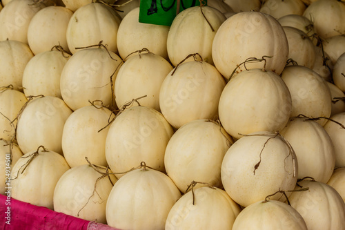 Fresh organic cantaloupe melons stacked on table for sale at loc