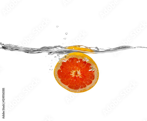 Fototapeta Naklejka Na Ścianę i Meble -  Grapefruit falling into water on white background