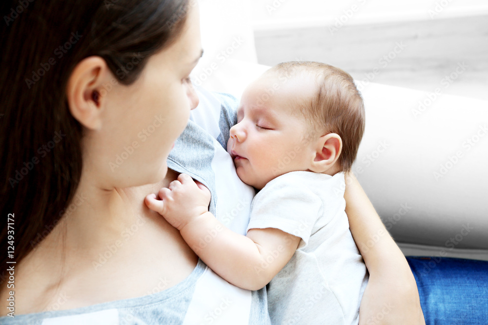 Woman holding cute sleeping baby, close up view