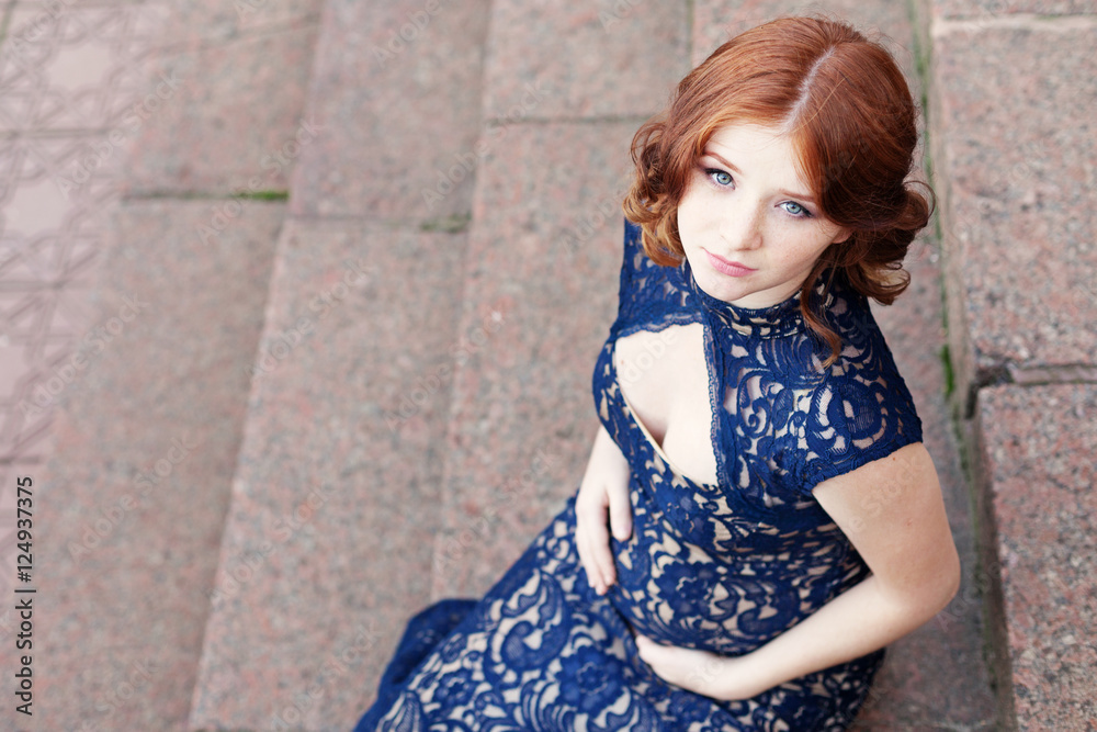 Beautiful young red hair pregnant woman sitting on stairs Beautiful young red hair pregnant woman sitting on stairs