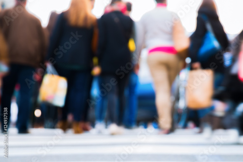 out of focus picture of people crossing a street