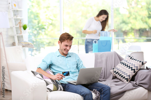 Young man with laptop shopp...