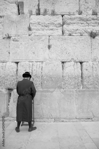 man praying at wall 1 bw