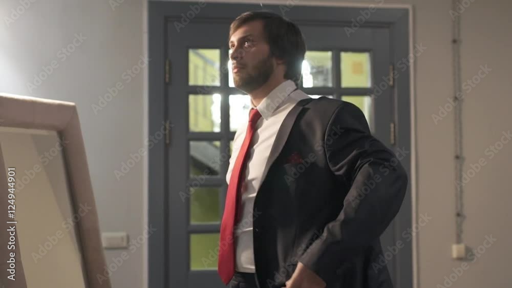 Brutal bearded man dressed in a beautiful wedding day. The groom wears a red tie around his neck close-up Brutal bearded man dressed in a beautiful wedding day. The groom wears a red tie around his neck close-up