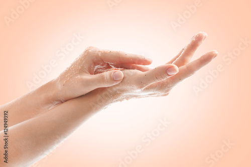 Female hands with scrub on color background. Skin care concept.