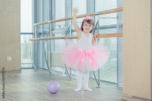 Adorable child dancing classical ballet in studio.