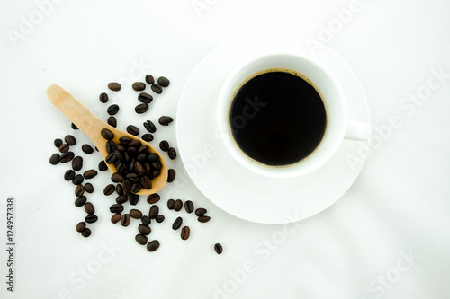 A cup of coffee and coffee beans. White background.