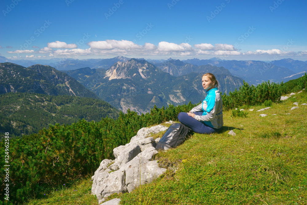 Young lady relaxing after hiking in alpine mountains