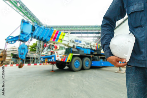 The engineering and safety helmets stood on the details of Industrial Crane operating and lifting 