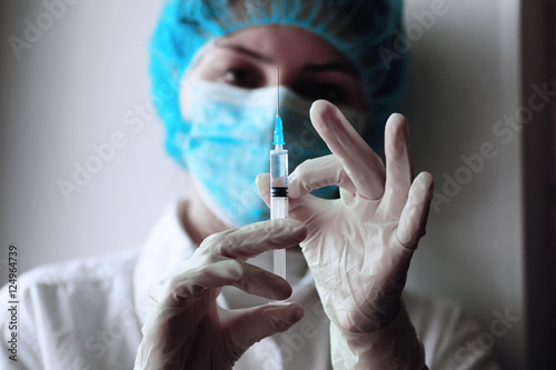 health worker dials the vaccine into a syringe