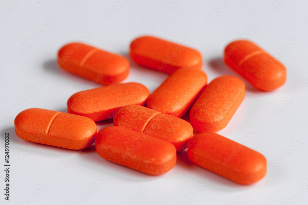 orange pills on a white background orange pills on a white background