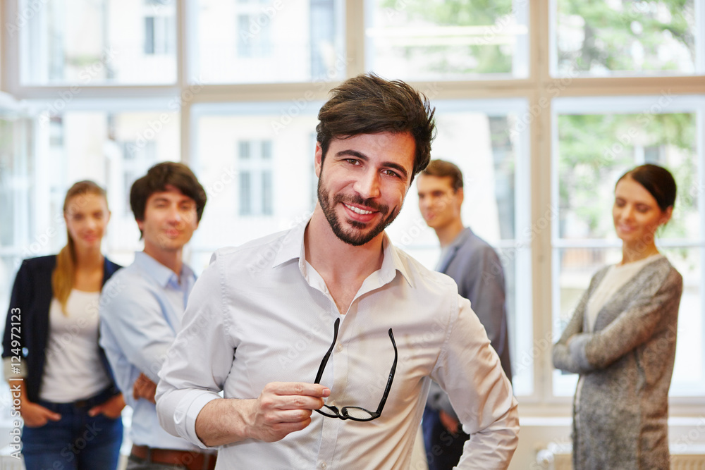 Junger Geschäftsmann vor Start-Up Team Junger Geschäftsmann vor Start-Up Team
