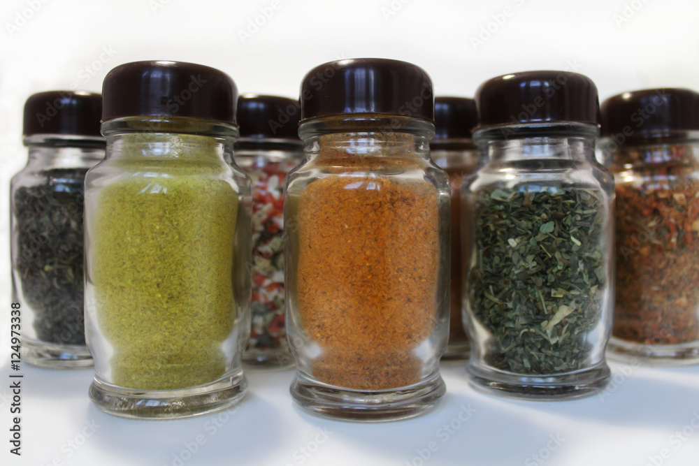 Spices in glass jars on a white background Spices in glass jars on a white background