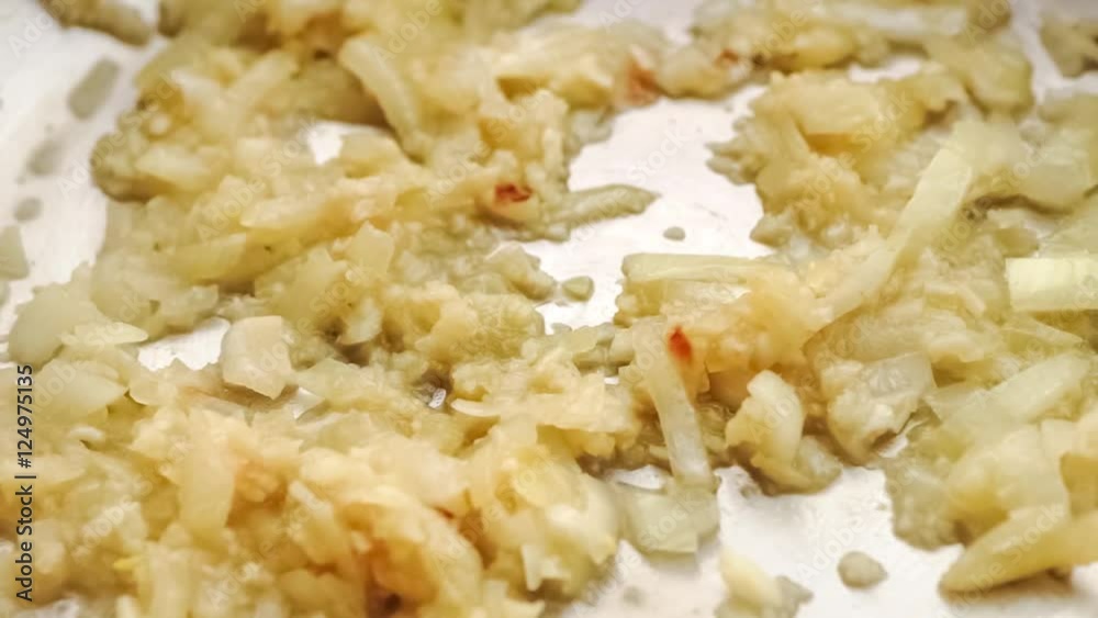 Closeup of sizzling hot onion and garlic cooking in pan as canned diced tomato is added to make pasta sauce, slow motion Closeup of sizzling hot onion and garlic cooking in pan as canned diced tomato is added to make pasta sauce, slow motion