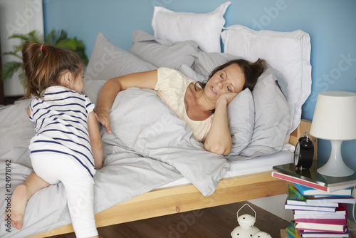 Bilde på lerret Girl disturbing her tired mum